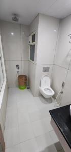 biała łazienka z toaletą i umywalką w obiekcie Hotel Ganga Amrit Haridwar Near Railway Station w mieście Haridwar