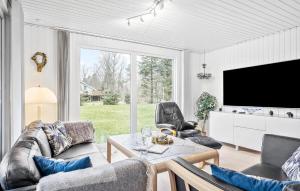 sala de estar con TV, mesa y sillas en Stunning Home In Hals With Sauna, en Hals