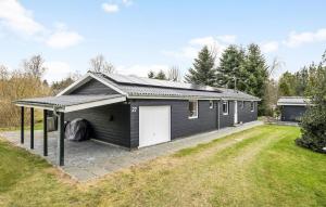 una casa negra con un garaje blanco en Stunning Home In Hals With Sauna, en Hals