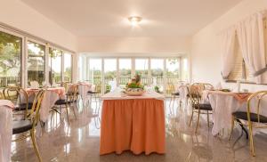a dining room with tables and chairs with flowers on them at Apartments and Rooms Michaela in Fažana