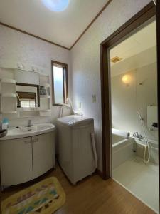 a bathroom with a sink and a tub and a mirror at Kitakaruizawa Morino Bessou NO7 in Kita-karuizawa