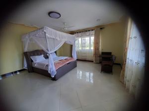 a bedroom with a bed with a canopy at Bigodi Community Lodge in Kamwenge