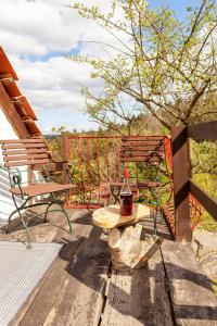 a bottle of alcohol sitting on a table on a deck at Scheunenloft- Hideaway - Ruheoase -Pool in Pirching am Traubenberg