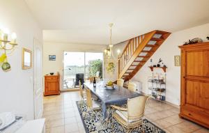 a living room with a table and a staircase at Stunning Home In Saint Pierre La Mer in Saint Pierre La Mer