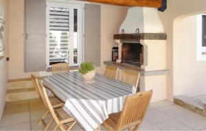 een eetkamer met een tafel en stoelen en een open haard bij La Villa De Sacha in Vedène