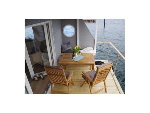 una mesa y sillas en un barco en el agua en Houseboat Lilliput, en Stralsund