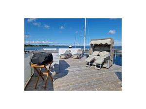 una terraza con tumbonas y una mesa en un barco en Houseboat Lilliput, en Stralsund