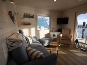 a living room with a blue couch and a television at Houseboat Lilliput in Stralsund