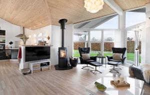 sala de estar con chimenea y TV en 3 Bedroom Pet Friendly Home In Juelsminde, en Sønderby