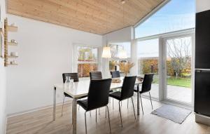 a dining room with a table and black chairs at Awesome Home In Juelsminde With Wifi in Sønderby