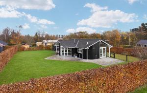 una casa en blanco y negro con un gran patio en 3 Bedroom Pet Friendly Home In Juelsminde, en Sønderby