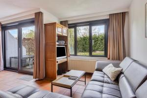 uma sala de estar com um sofá e uma televisão em Colibri 3 met parking em Nieuwpoort