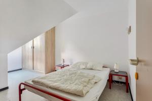 um quarto branco com uma cama e duas mesas em Colibri 3 met parking em Nieuwpoort