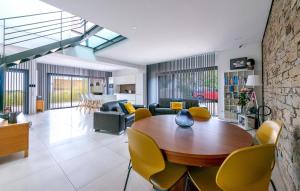 a living room with a wooden table and yellow chairs at 3 Bedroom Amazing Home In Allauch in Allauch