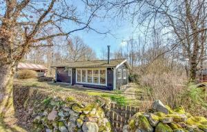 a small house on a hill with a stone wall at 3 Bedroom Stunning Home In Hrby in Hörby
