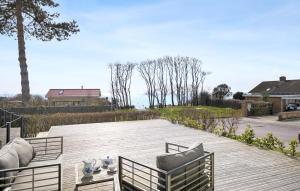 a wooden deck with two chairs and a table at Amazing Home In Korsr With House Sea View in Korsør