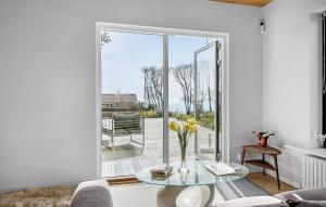 a living room with a glass table in front of a sliding glass door at Amazing Home In Korsr With House Sea View in Korsør