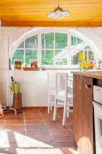 uma cozinha com uma janela arqueada, uma mesa e cadeiras em Scheunenloft- Hideaway - Ruheoase -Pool em Pirching am Traubenberg