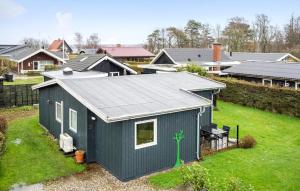un pequeño cobertizo azul en un patio con casas en Stunning Home In Brkop With Wifi, en Børkop