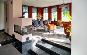 a living room with a fireplace and a dining room at 3 Bedroom Stunning Home In Fluitenberg in Fluitenberg