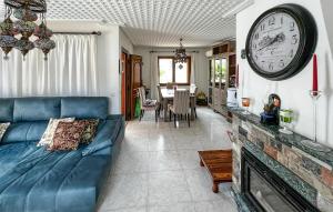 un soggiorno con divano e orologio a muro di Beautiful Home In Port Adriano With Kitchen a El Toro