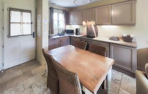 a kitchen with a wooden table and chairs in a room at Nice Home In Saint-Laurent-De-La-Ca in Saint-Laurent-de-la-Cabrerisse