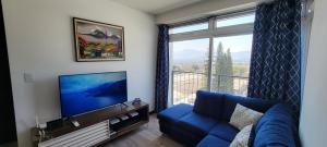 a living room with a blue couch and a large window at Apartamento Parada 50 in Guatemala