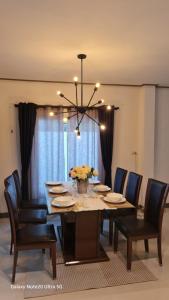 een eettafel met stoelen en een kroonluchter bij 3bed3room in Ban Rangeng