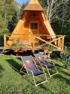 dos sillas frente a una casa en el árbol en Lepa Lopa resort, en Stahovica