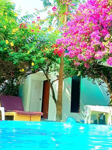a swimming pool with a tree with pink flowers at OASIS Phuket Airport in Ban Bo Sai Klang