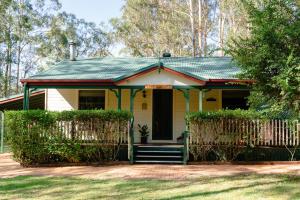 una pequeña casa amarilla con techo verde en Telegraph Retreat Cottages en Telegraph Point