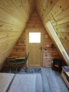 una habitación con una silla y una puerta en una cabaña de madera en Lepa Lopa resort en Stahovica
