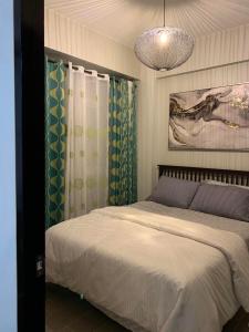 a bedroom with a bed and a chandelier at The Nest in Oceanway Boracay in Boracay