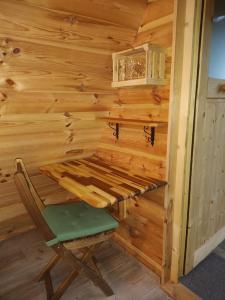 Cabaña de madera con banco y silla en Lepa Lopa resort, en Stahovica