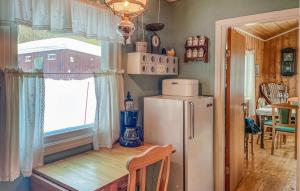 OsにあるGorgeous Home In Os I Østerdalenのキッチン(冷蔵庫、テーブル付)、窓が備わります。