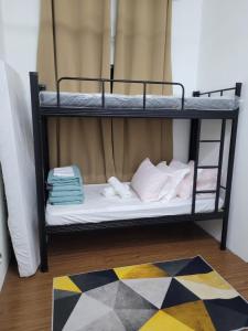 two bunk beds in a room with towels and a rug at MyKampung Homestay in Rembau