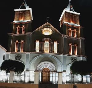 a church with a clock on top of it at night at Departamento Riobamba in Riobamba