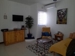 a living room with a bed and a tv at East Breeze Penthouse in Mġarr