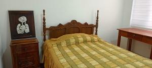 łóżko z drewnianym zagłówkiem i komodą w sypialni w obiekcie Departamento Riobamba w mieście Riobamba