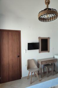 a room with a table and a chair and a door at ANATOLI ROOMS SERIFOS in Serifos Chora