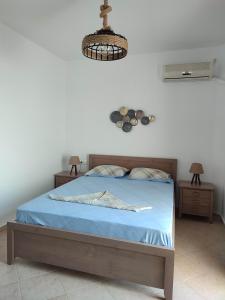 a bedroom with a bed with blue sheets and a light at ANATOLI ROOMS SERIFOS in Serifos Chora