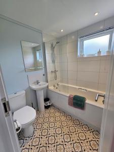 a bathroom with a toilet and a tub and a sink at Peacock Lodge - Sleeps 4 - 2 Bedrooms in East Looe +39 photos