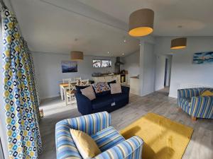 a living room with two couches and a dining room at Peacock Lodge - Sleeps 4 - 2 Bedrooms in East Looe