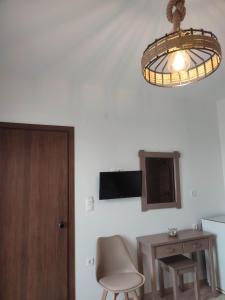 a room with a chair and a table and a light at ANATOLI ROOMS SERIFOS in Serifos Chora +8 photos