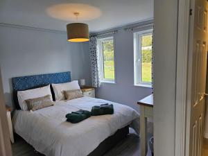 East LooeにあるPeacock Lodge - Sleeps 4 - 2 Bedroomsのベッドルーム1室(ベッド1台、バッグ2つ付)