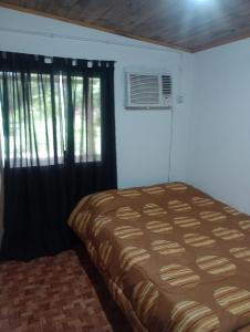 a bedroom with a bed and a window with curtains at Esquina Sur in Esquina