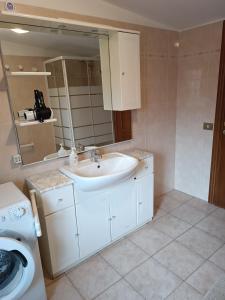 a bathroom with a sink and a washing machine at Villino fiera di Roma e aeroporto Fiumicino in Ponte Galeria