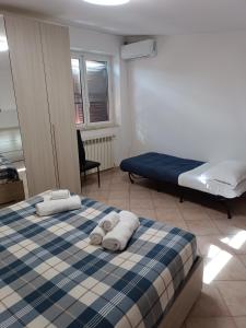 1 dormitorio con 1 cama con toallas en Villino fiera di Roma e aeroporto Fiumicino, en Ponte Galeria