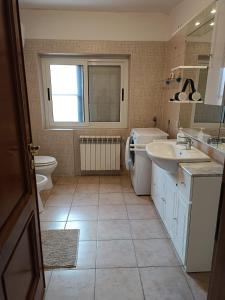 La salle de bains est pourvue d'un lavabo, de toilettes et d'une fenêtre. dans l'établissement Villino fiera di Roma e aeroporto Fiumicino, à Ponte Galeria