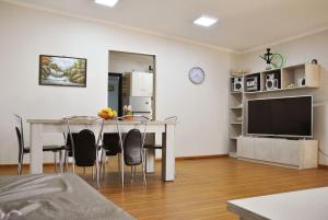 ein Wohnzimmer mit Tisch und Stühlen und einem Fernseher in der Unterkunft Bungalow Thalassa, am Strand und mit Mini-Pool in Kalamaki